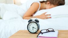 A Young Woman Putting Her Alarm Clock Off In The Morning Royalty Free Stock Photo