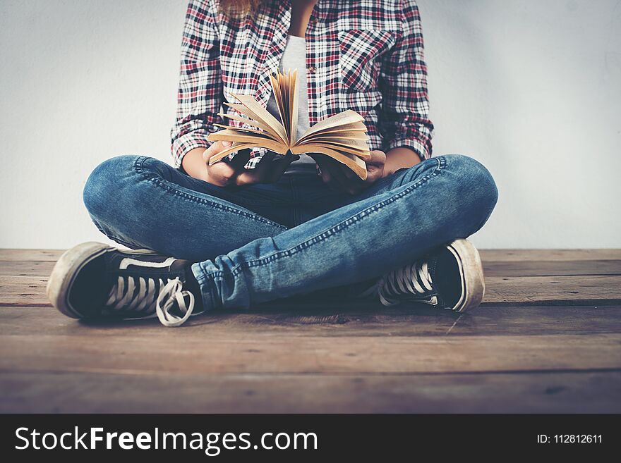 Close-up Of Hipster Woman Hands Holding Open Book Sitting On Woo