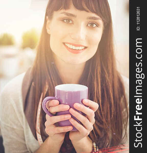 Modern young fashion designer with cup at studio