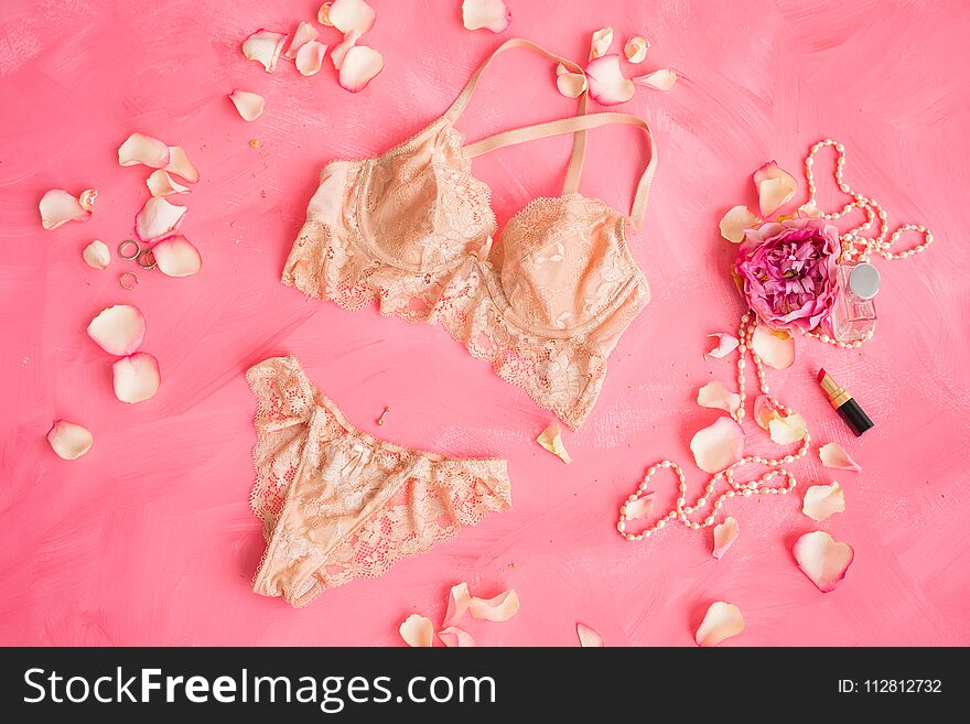 Beige women`s lingerie on pink background, underwear concept