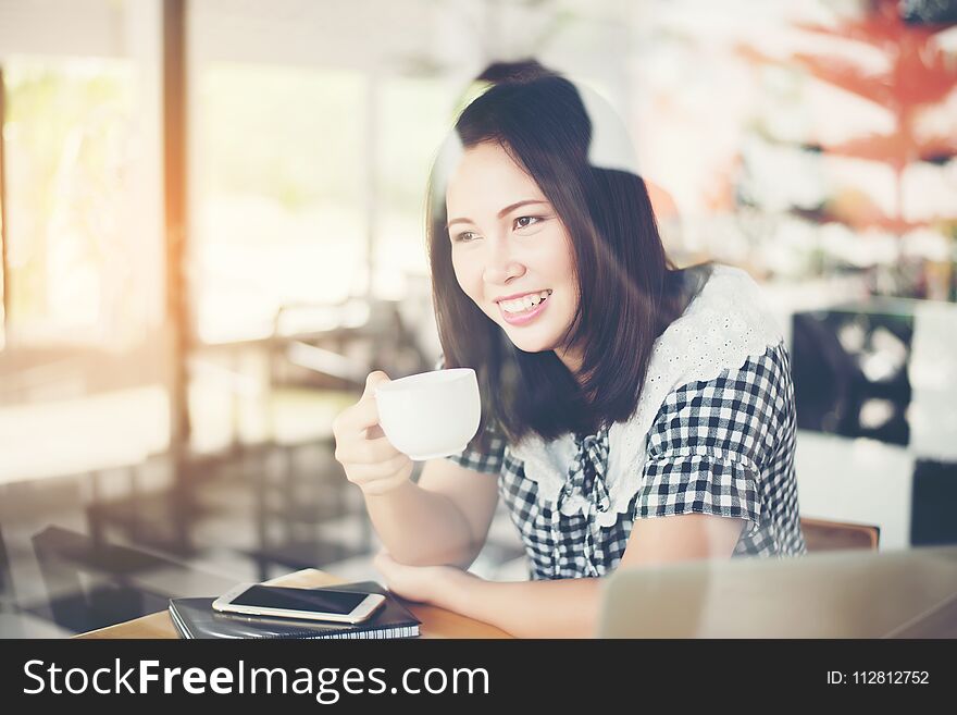 Beautiful woman sitting and drinking coffee at cafe.