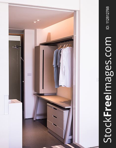 Modern walk in closets design interior with clothes hanging on rail