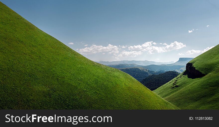 Picturesque Green Hill And Mountain Range On A Sunny Summer Day. Elbrus Region, Northern Caucasus, Russia