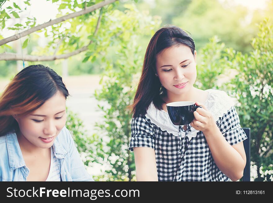 Two friends smiley enjoying working together in a coffee shop.