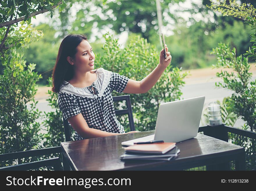 Young Beautiful Woman Sitting At A Table In A Cafe, Drinking Coffee And Doing Selfie.