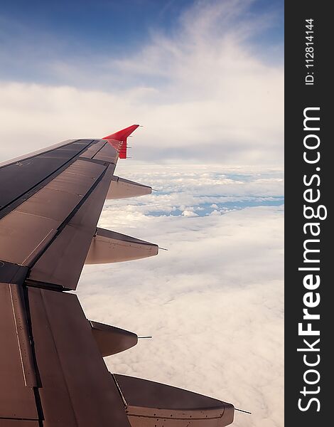 Beautiful view through the window to the sky with clouds and the horizon under the wing of the aircraft. Beautiful view through the window to the sky with clouds and the horizon under the wing of the aircraft.