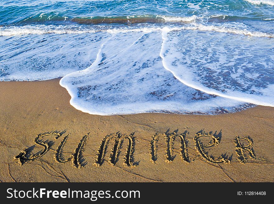 The inscription summer on sand beach on the soft sea wave background. The inscription summer on sand beach on the soft sea wave background.