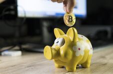 Hand Putting Golden Bitcoin In To Piggy Bank Money Box With A Computer On Background. Cryptocurrency Investment Concept Stock Images