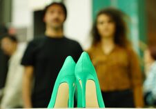 Unidentified Couple Watching The Green Woman Shoe In The Vitrine Stock Photo