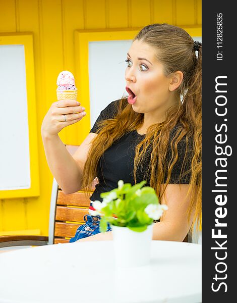 Happy funny shocked young woman with long brown hair eating ice cream having fun. Happy funny shocked young woman with long brown hair eating ice cream having fun.