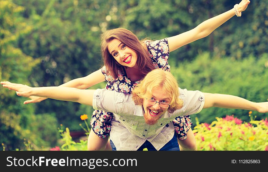 Relationship, summer love concept. Smiling women riding piggyback on men shoulders. Happy young couple having fun together outdoor. Relationship, summer love concept. Smiling women riding piggyback on men shoulders. Happy young couple having fun together outdoor