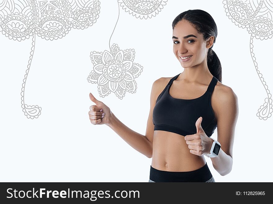 Kind trainer putting her thumbs up and smiling to her pupils