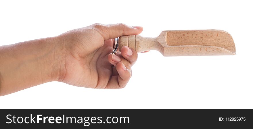 Hand holding a wooden spoon with spice on white background