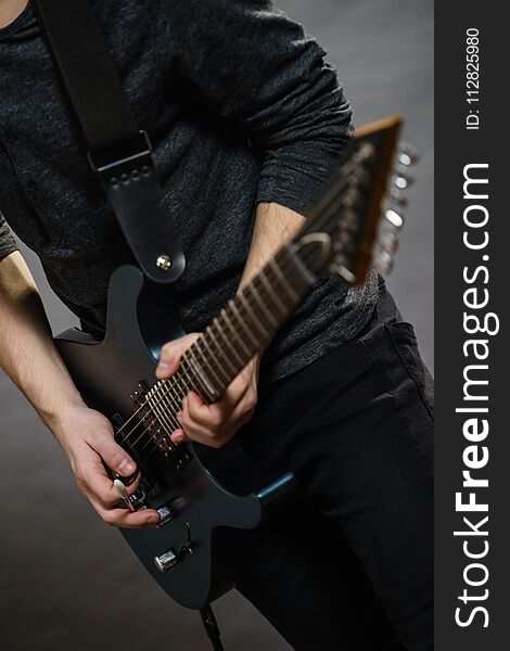 Male hands with electric guitar. Close up, part body adult person is holding instrument and playing. Hobby, music concept. Male hands with electric guitar. Close up, part body adult person is holding instrument and playing. Hobby, music concept