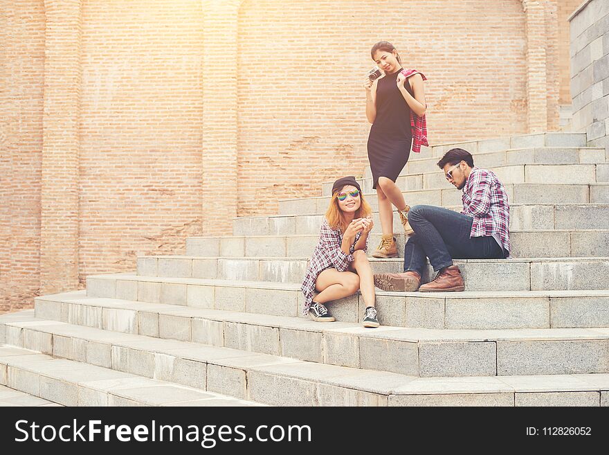 Group of hipster students sitting on a staircase talking and relaxing after school together.