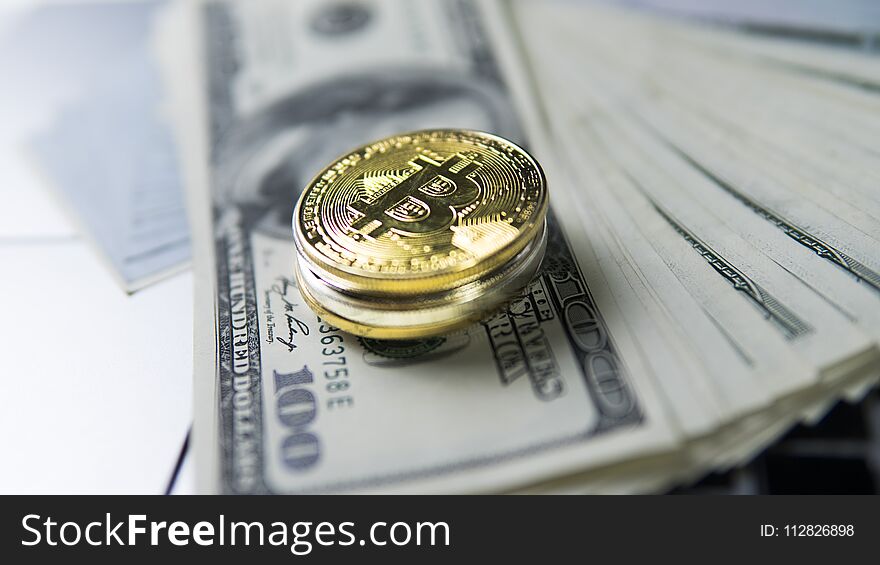 Bitcoin coin with laptop and us dollars. Bitcoin golden coins on a dollar banknotes and laptop. Cryptocurrency