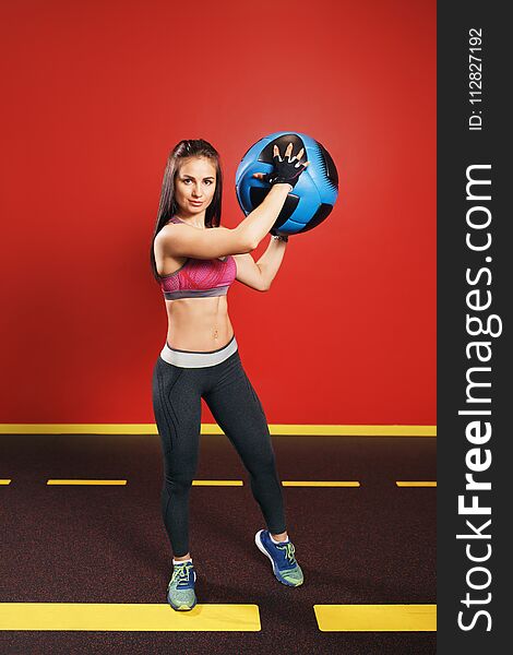 Young woman exercise with medicine ball in gym.