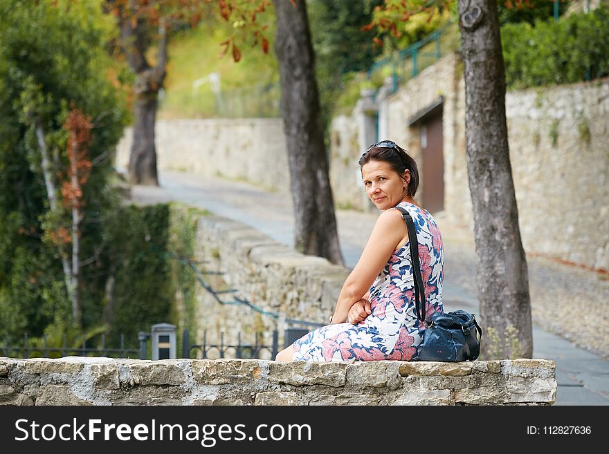 Bergamo, Italy. Beautiful Girl In A White Summer Dress In The City.