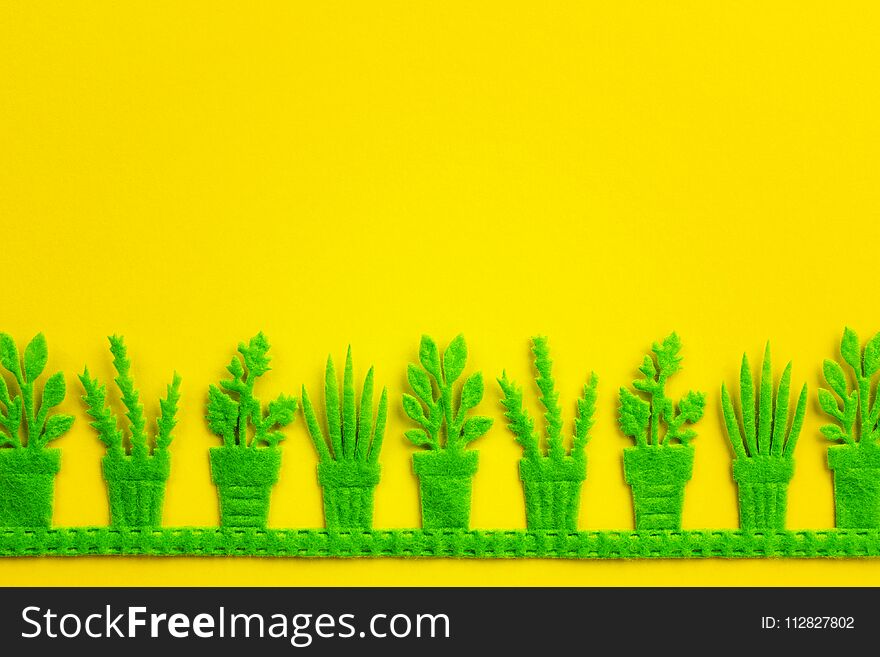 Silhouettes of green pots with plants on yellow background.