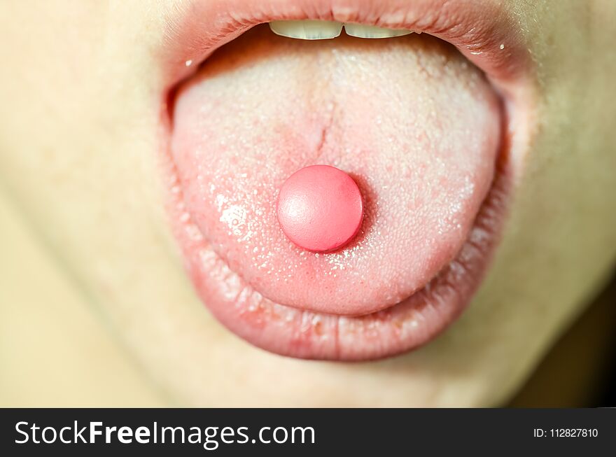 Young Drug Addict Woman Mouth Holding Tablet Or Pill On The Tongue, Close Up Selective Focus, Addiction Concept