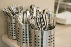 Many Clean Kitchen Appliances: Spoons, Forks, Knives Lie Together. Royalty Free Stock Photos
