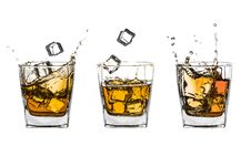 Three Glasses Of Splashing Whiskey With Ice On White Stock Photography Three Glasses Of Splashing Whiskey With Ice On White Stock Photography