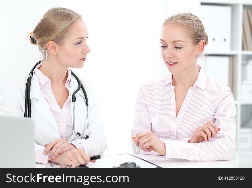 Blonde female doctor and patient during personal consulting in hospital. Health care concept