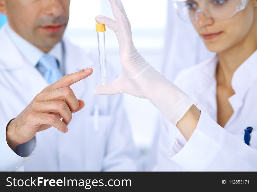Team of scientific researchers in laboratory studying substances or blood sample. New vaccine for pharmacology industr