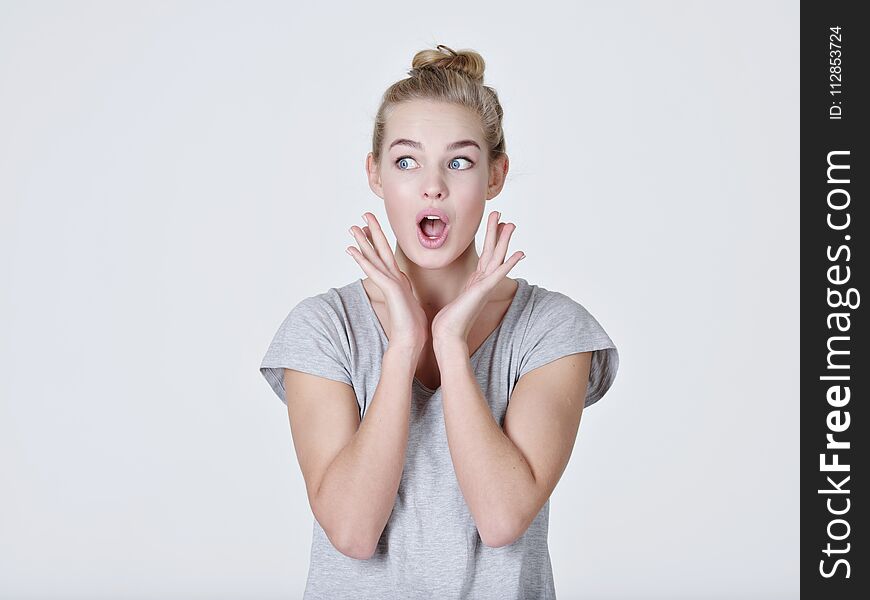 Young shocked woman on white background