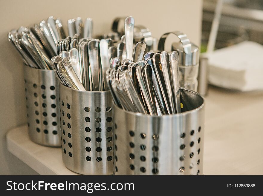 Many Clean Kitchen Appliances: Spoons, Forks, Knives Lie Together.