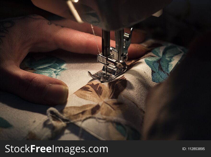 Tailor at Work on Sewing Machine with human hand