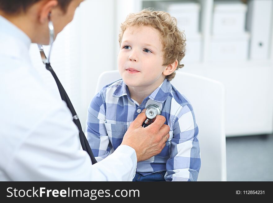 Doctor And Child Patient. Physician Examines Little Boy By Stethoscope. Medicine And Children`s Therapy Concept