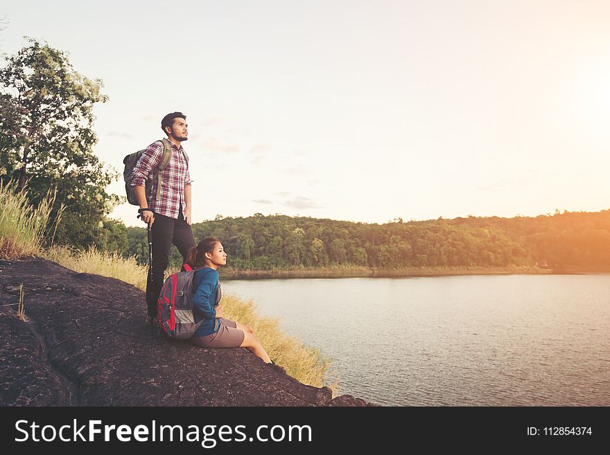 Couple Having Rest On The Top Of Mountain Below Lake View During