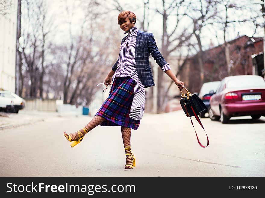 Woman in Purple Top and Plaid Skirt Near Car