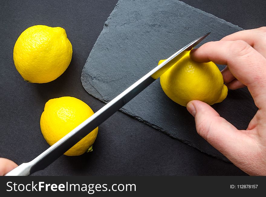 Human Slicing Yellow Lemon