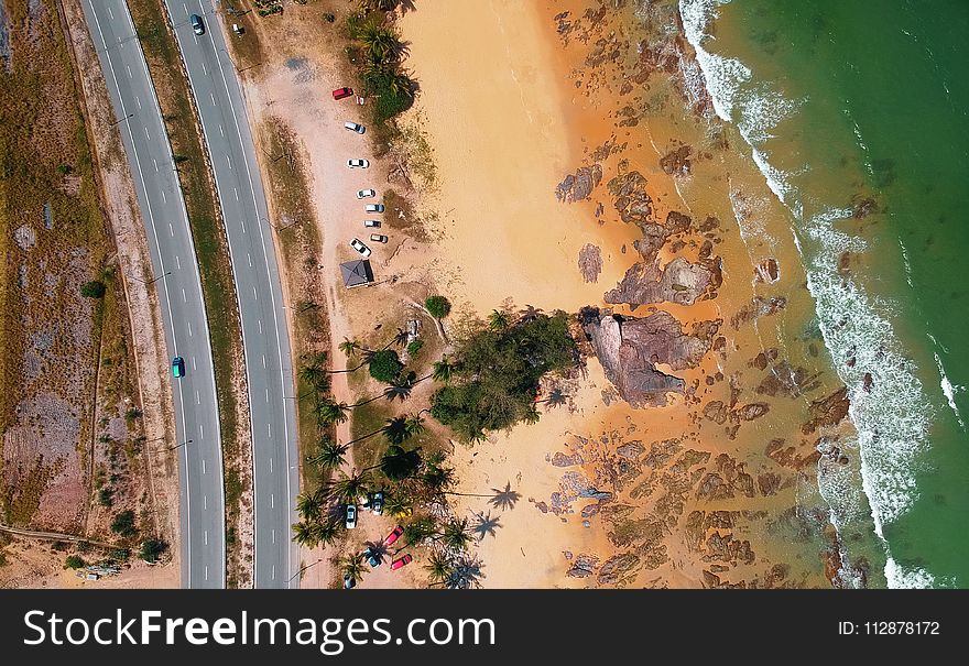 Aerial Photo of Seashore Near Two Lanes of Wide Road