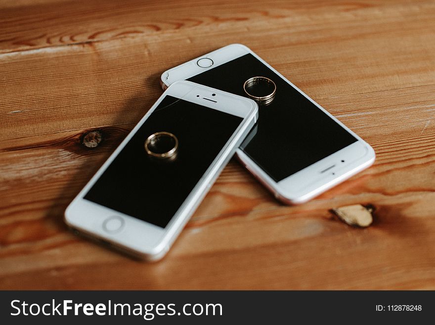 Two Rose Gold Iphone 6s on Brown Wooden Surface