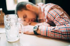 Drunk Again. Drunk Male Customer Leaning At The Bar Counter And Sleeping While Glass With Beer Standing Near Him Stock Photos