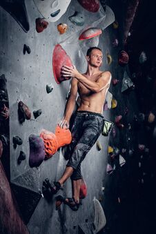 Man Climbing On An Indoor Climbing Wall. Royalty Free Stock Photography Man Climbing On An Indoor Climbing Wall. Royalty Free Stock Photography