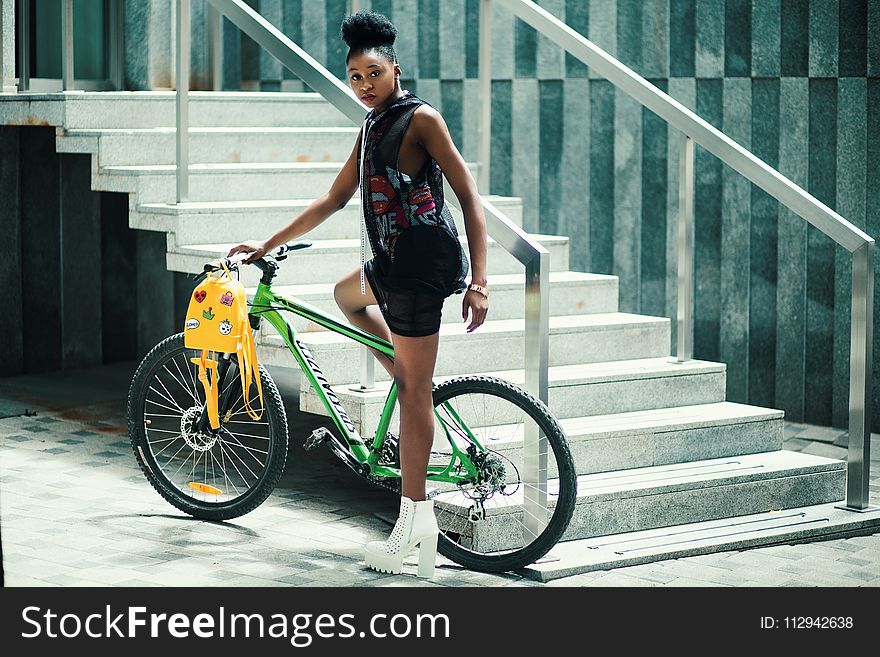 Woman Wearing Black Dress Riding Bicycle Near Stairs