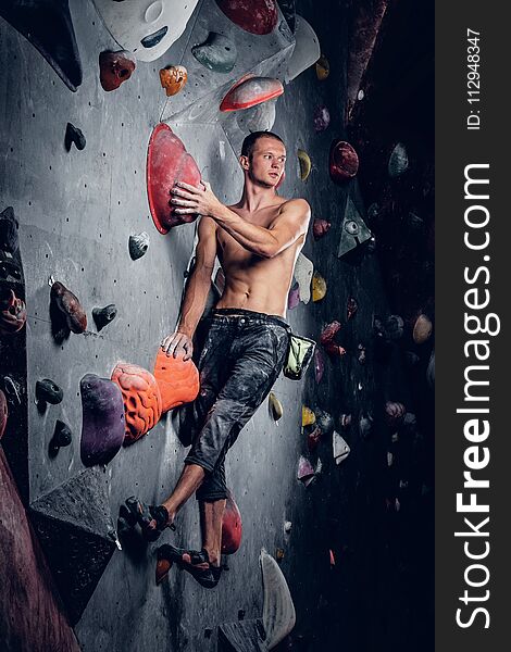 Man climbing on an indoor climbing wall.