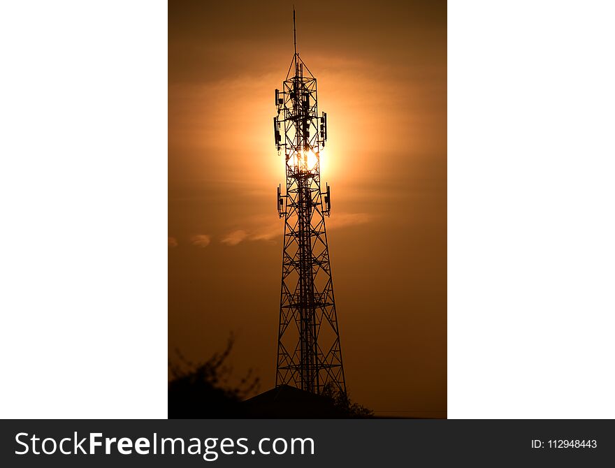 Wireless Communication Antenna With sunrise bright sky.Telecommunication tower with antennas with orange sky.