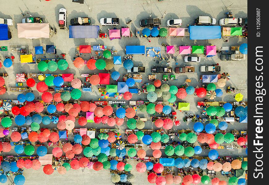 Aerial view from camera drone of flea market with colorful umbrellas and tents under evening sunlight, Thailand. Aerial view from camera drone of flea market with colorful umbrellas and tents under evening sunlight, Thailand