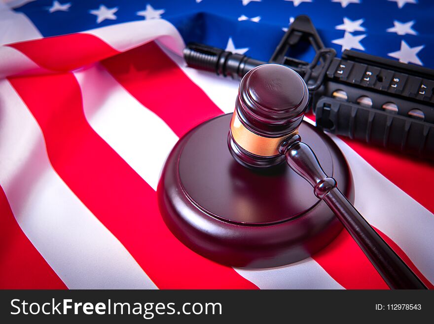 Gavel with gun on background of USA flag.