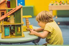 Boy Playing With Wooden House In Kindergarten Royalty Free Stock Image