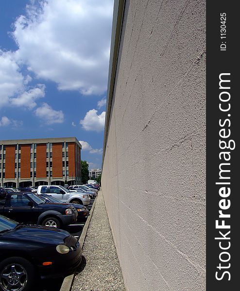 Cars, buildings and parking lot with blue sky and clouds. Cars, buildings and parking lot with blue sky and clouds