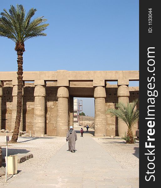 The touristic place Luxor with palm trees, pillars and a walking man