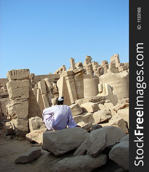 Man sitting on the ruins of Luxor