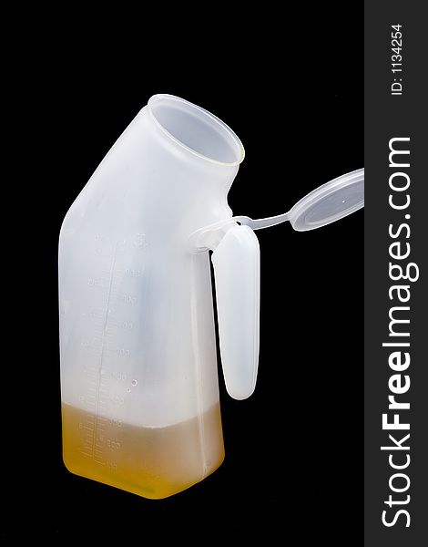 A bedside hospital urinal partially filled (don't worry, it's apple juice) on a black background. A bedside hospital urinal partially filled (don't worry, it's apple juice) on a black background.