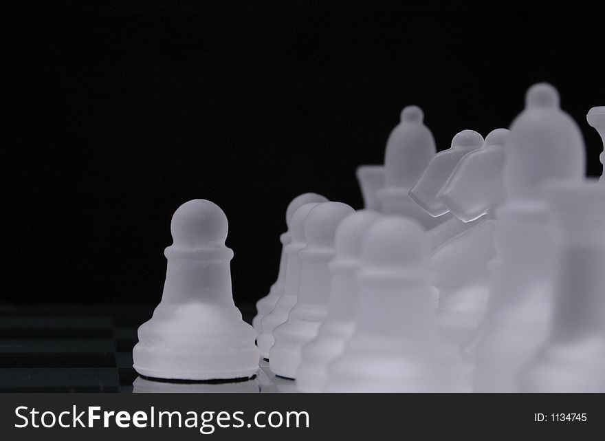 A pawn from a glass chess set is out of line with rows of pieces from the same side. A pawn from a glass chess set is out of line with rows of pieces from the same side.